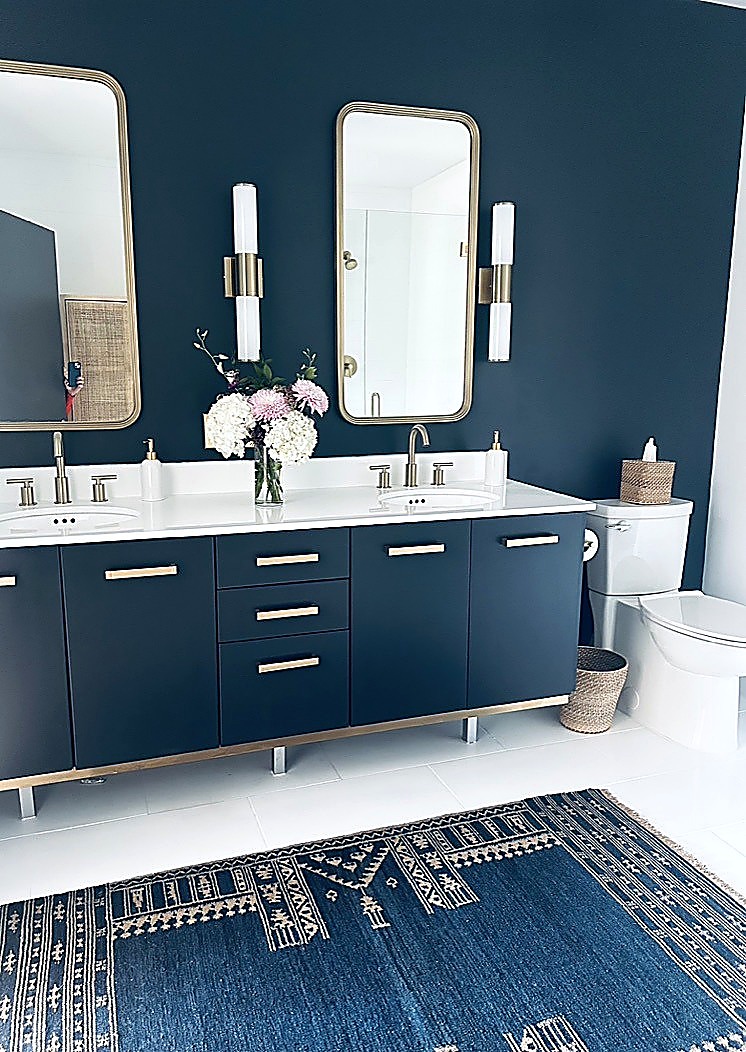Navy bathroom vanity wall with gold sconces